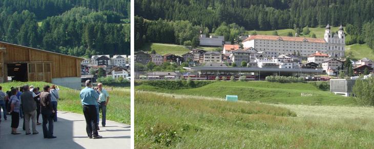 Freilaufstall (Holzkonstruktion) nach dem bekannten Architekten Gion Caminada (links) mit Kloster Disentis im Hintergrund (rechts)